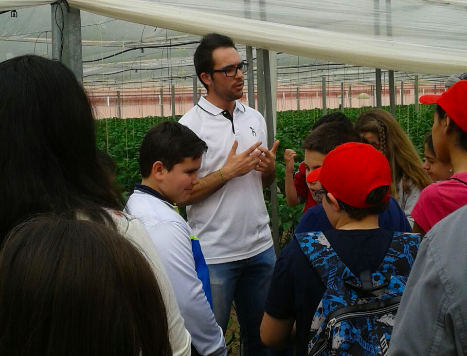 Mostrando a un grupo de niños en la explotación cómo funciona la agricultura ecológica